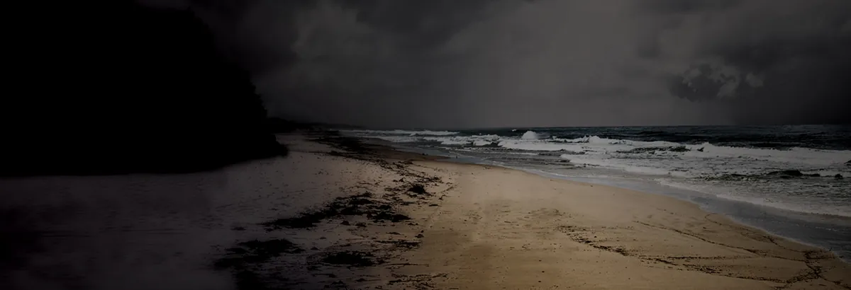 A dark, empty beach at dusk